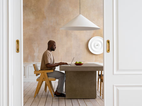 First-generation professional working confidently on a laptop at home, symbolizing overcoming self-doubt and building career success
