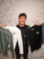 Photo of one of Jumping Fox Software employees holding up Jumping Fox Software clothing merch.