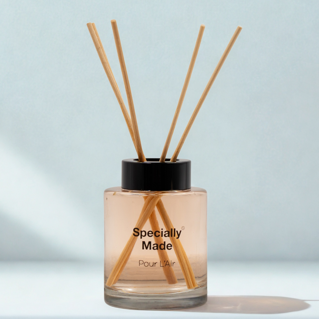 vanilla caramel diffuser - glass jar with a black lid and diffuser sticks sticking out -on a minimalistic white background