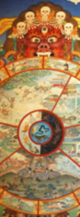 Traditional_bhavachakra_wall_mural_of_Yama_holding_the_wheel_of_life,_Buddha_pointing_the_