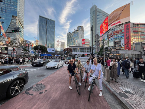 Group photo of guests with bicycles at Shibuya Crossing during a daytime COG EXPLORER bike tour