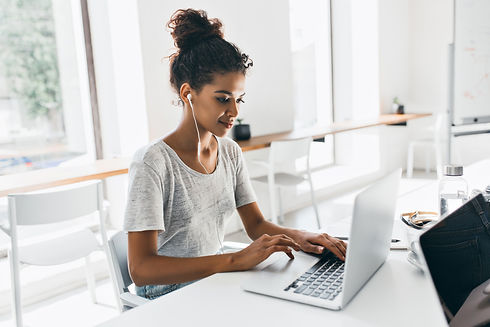 romantic-african-woman-with-trendy-hairstyle-sitting-at-her-workplace-and-analysing-data-i