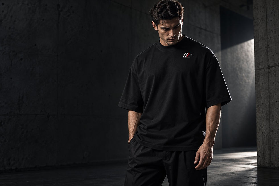 Editorial image of a model wearing an oversized black high-neck T-shirt with a small chest mark.