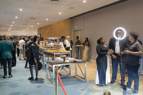 Guests networking and gathering around a food station during a break at a business event