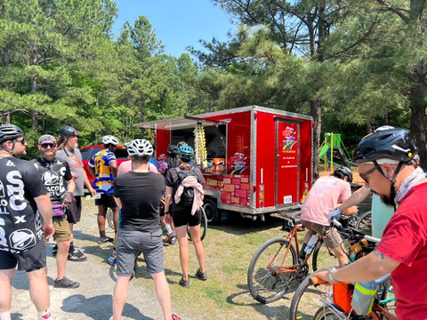 Bikers enjoying hot dogs after a day of biking.