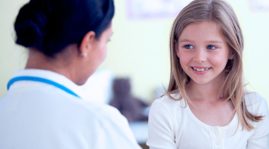 Dark-haired occupational therapist looking a a smiling client.