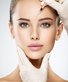 Portrait of young Caucasian woman getting botox cosmetic injection in forehead. Beautiful