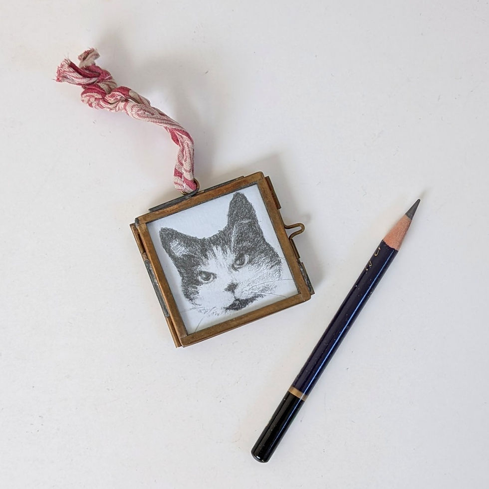 Thumbnail: a miniature cat portrait on a table with a graphite pencil