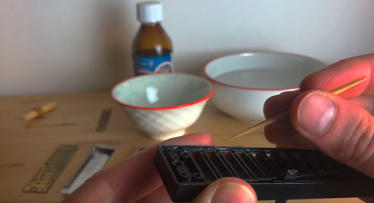 Photo of a man's hand and a harmonica, man is cleaning his harmonicas