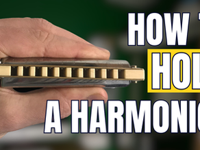 Hand holding harmonica, text reading 'HOW TO HOLD A HARMONICA'