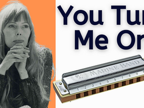 A thumbnail with a photograph of Joni Mitchell on the left hand side, against an orange background, and on the right hand side, against a white background, a photograph of a Hohner Marine Band harmonica and the text You Turn Me On written in black