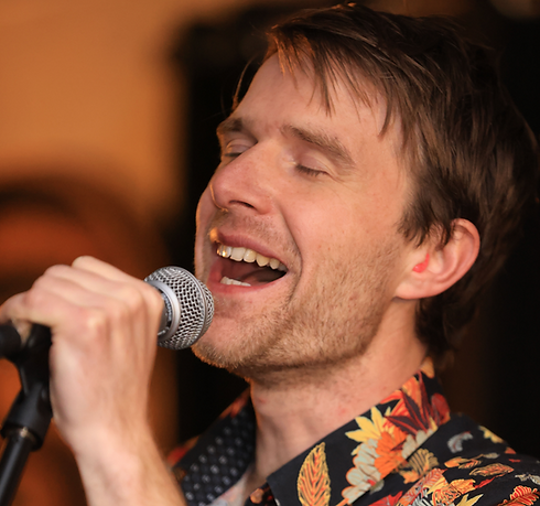 Close up of man singing into microphone.