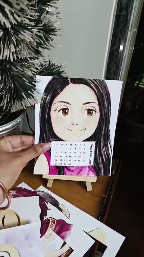Thumbnail: Personalised 2026 mood calendar displayed on a wooden easel with the customer’s face on the front cover card