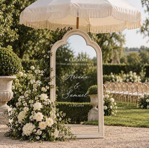 Whitewash wedding signage mirror styled as a welcome sign with flowers and fringed parasol