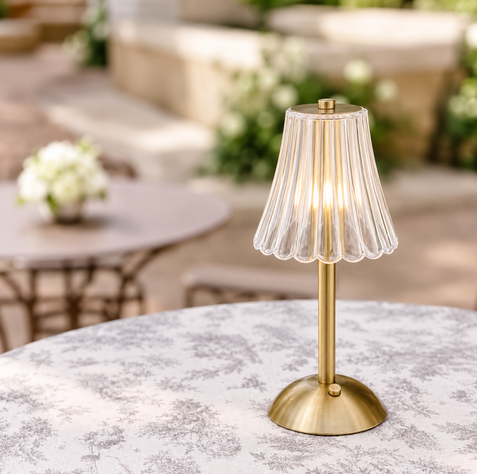 Close-up of gold LED table lamp with clear fluted shade