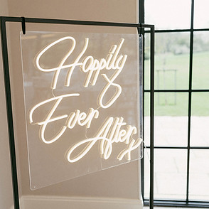 happily ever after neon sign hanging from black metal frame