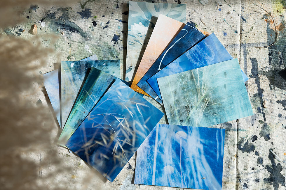 Thumbnail: Blue and green art prints fanned on a paint-splattered surface
