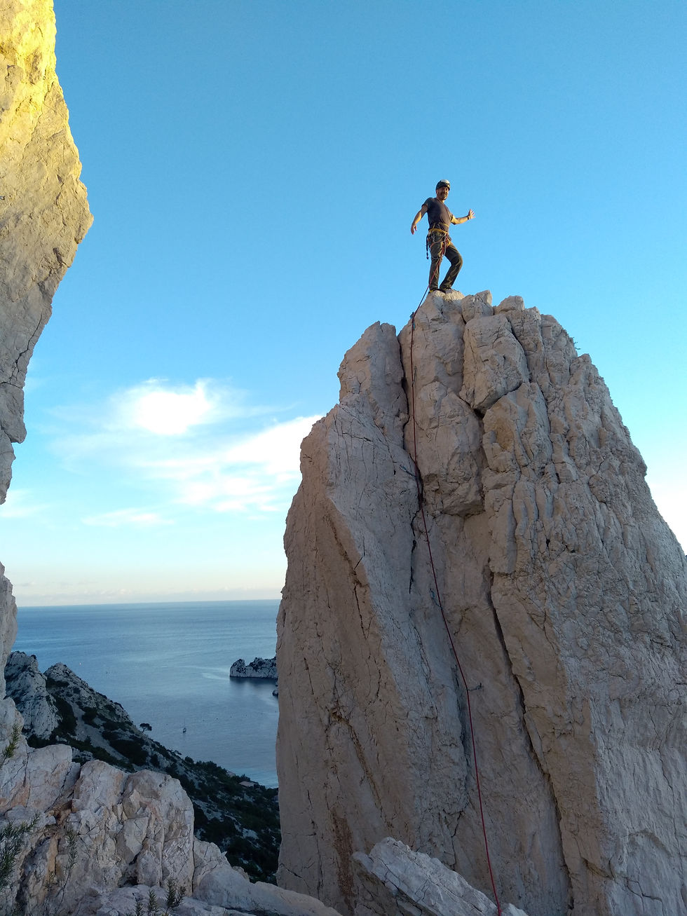 Une grimpeuse heureuse debout sur le pouce face à la mer