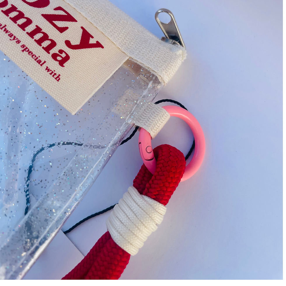 Thumbnail: Close-up of transparent glitter PVC pouch showing red rope wrist strap and pink ring.