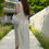 Thumbnail: Woman in ivory sundress wearing Ossl crochet drawstring pouch cross-body on forest path.