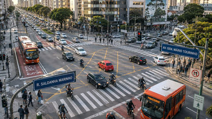 Cruzamento movimentado de Curitiba com carros, ônibus, motocicletas e pedestres no horário de pico.