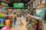 Interior de um grande pet shop em Curitiba com corredores de produtos, tutores e animais de estimação.