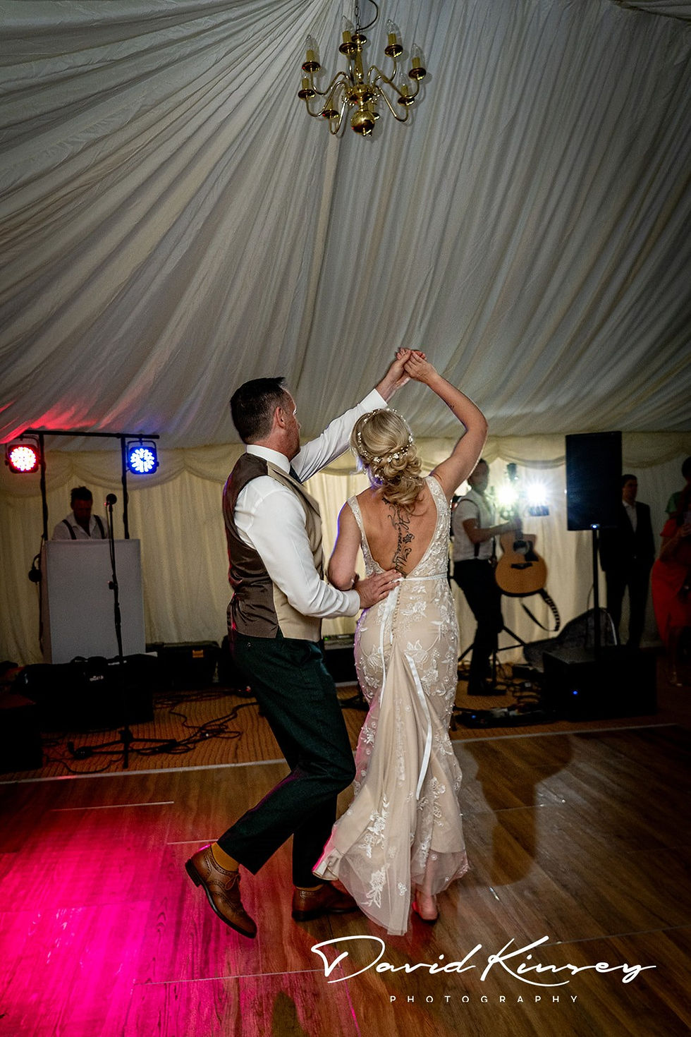 Wedding couple dance in marquee with pink and blue disco lights