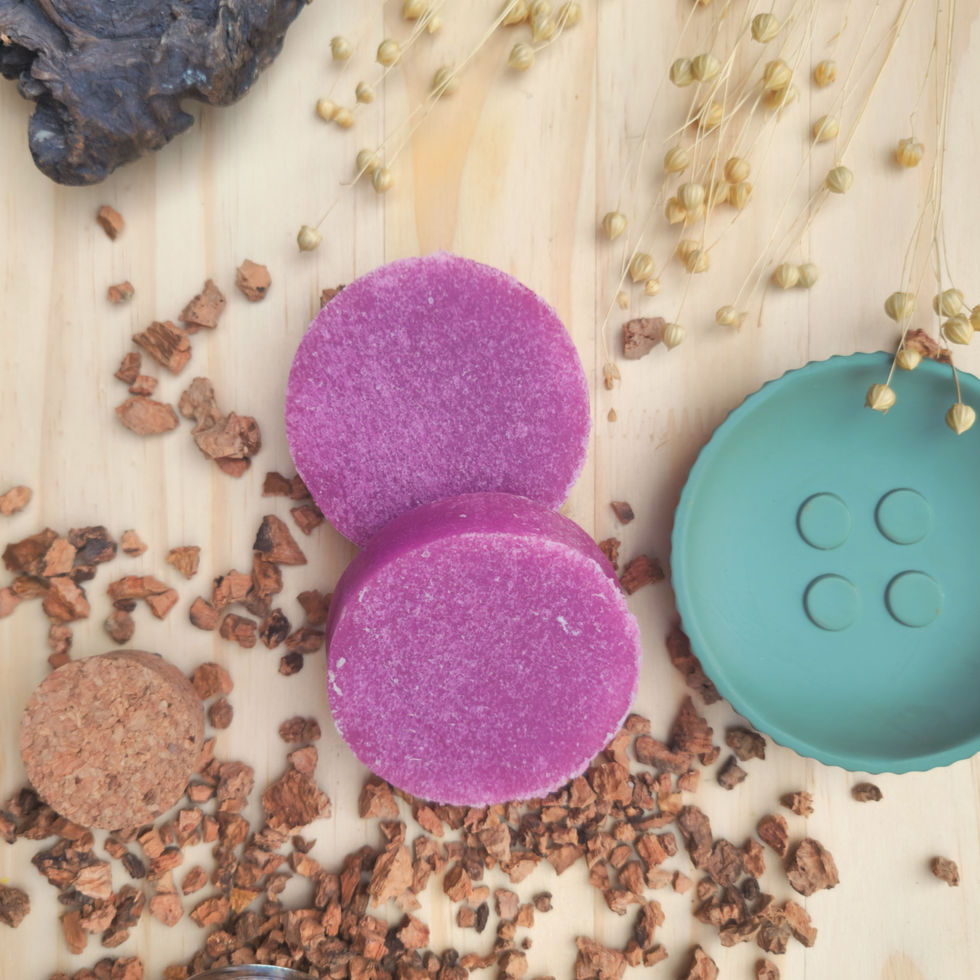 Deux tranches de savon éponge violette, à la Lavande posées sur une planche avec des copeaux en bois autour