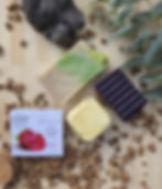 Un savon a base d'huile d'olive vert, des feuille de savon rose, un galet de douche jaune, savon aromathérapie violet
