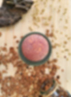 Bombe de bain orange chocolat au karité posée sur support vert d'eau avec décoration en bois