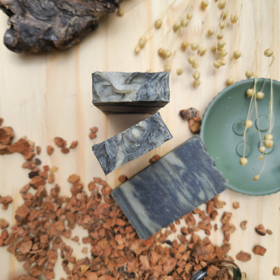 Trois tranches de savon artisanal gris à la boue de la Mer Morte et huile d'olive posées sur un socle vert d'eau