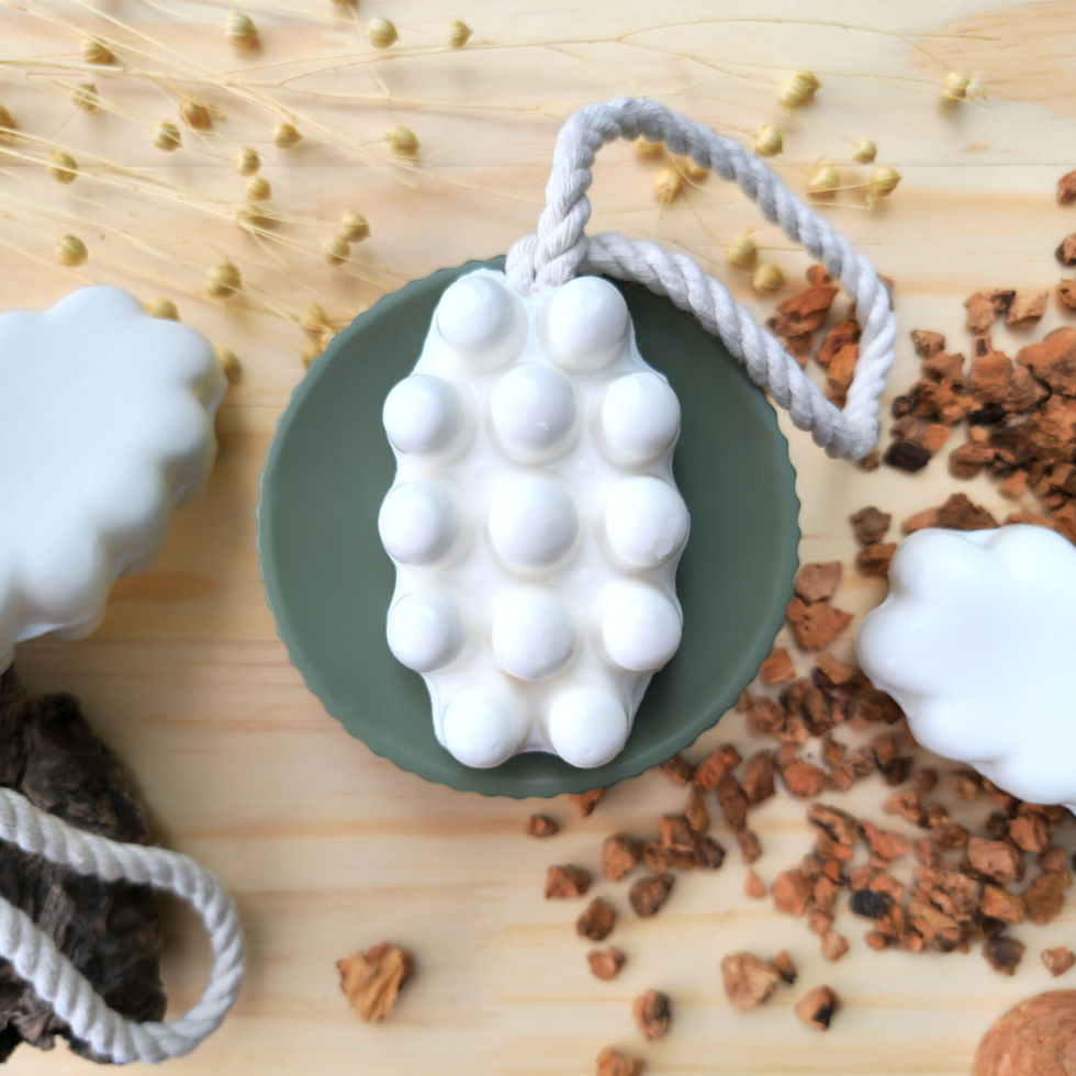 Savon de massage blanc avec nodules au lait d'ânesse bio posé sur un socle vert d'eau