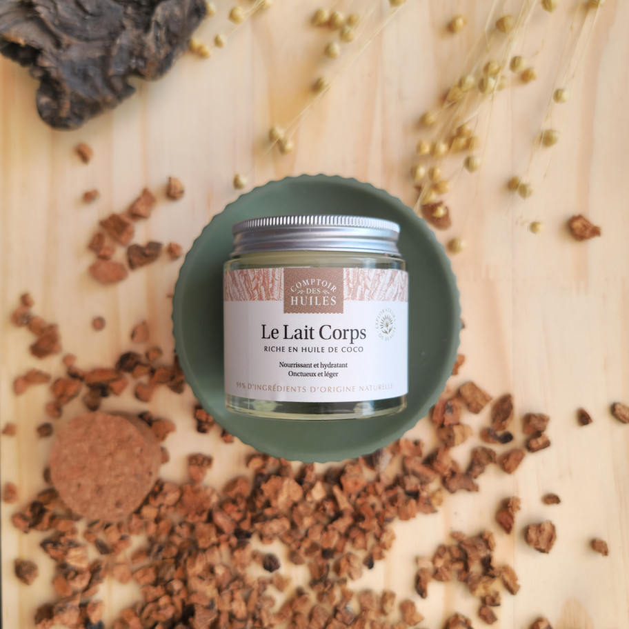 Un pot de lait corps en verre est posé sur un support pour bien le mettre en avant, étiquette poser face à nous.