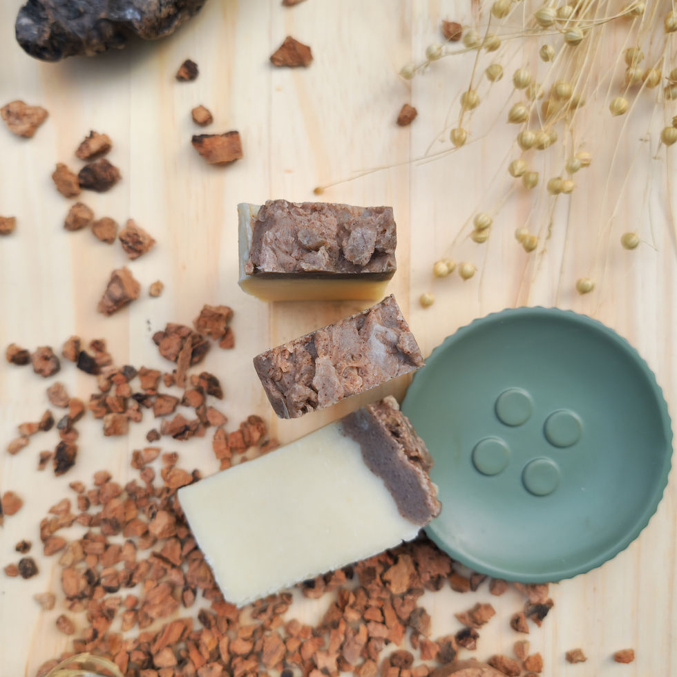Trois tranches de savon artisanal blanc au lait de chèvre et huile d'olive posées sur un socle vert d'eau