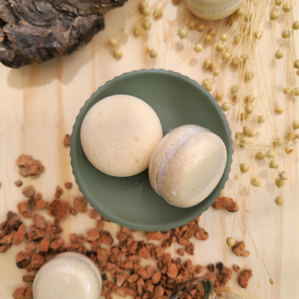 Deux macarons effervescents amande beige et blanc posés sur un socle vert d'eau