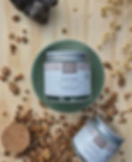 Pot d'huile de coco bio fermé posé sur un socle vert d'eau avec des copeaux de bois