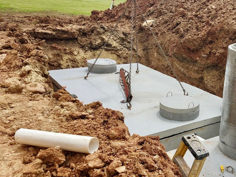 A septic holding tank is being installed at a construction site.