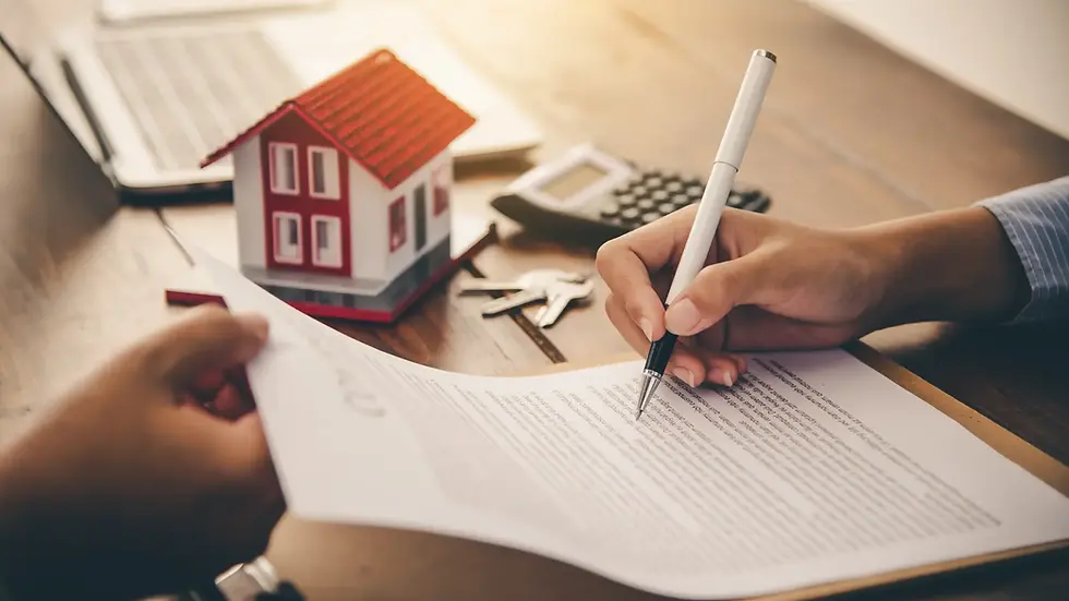 Pessoa assinando um contrato de penho e uma casa pequena com chaves numa mesa