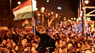 A man waves a Hungarian flag as he celebrates in the streets the Hungarian parliamentary elections, April 12, 2026.