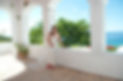 A bride on a patio sitting on the window ledge overlooking the Caribbean sea at her destination wedding. 