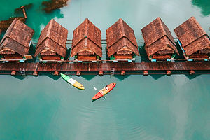 Aerial view of Praiwan Rafthouse floating bungalows on emerald water at Cheow Lan Lake