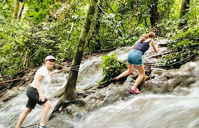 Waterfalls deeper in the Cheow Lan Lake area form part of a wider lake and forest journey, where reaching the surrounding landscape may involve travelling by longtail boat before continuing into the forest.