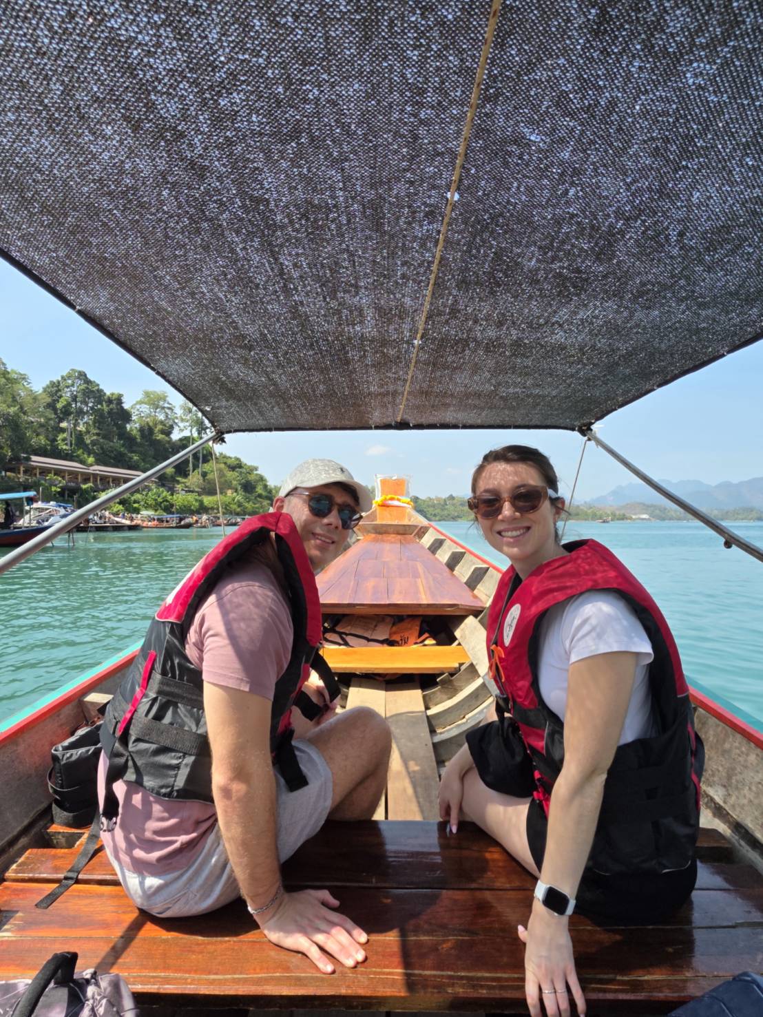 Travelers observing Cheow Lan Lake wildlife quietly from a longtail boat at a respectful distance