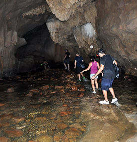 Walking through flowing water inside Nam Talu Cave