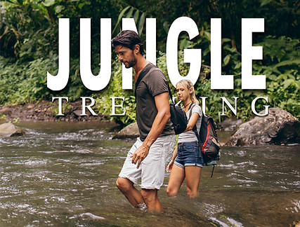 Travelers crossing a rainforest river during a jungle trekking adventure in Khao Sok National Park