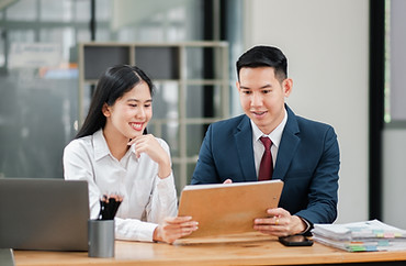 two-business-professionals-modern-office-setting-collaborating-discussing-documents-wooden