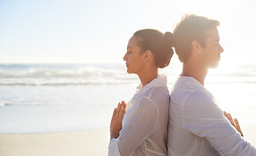 Couple méditant sur la plage