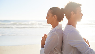 Couple méditant sur la plage