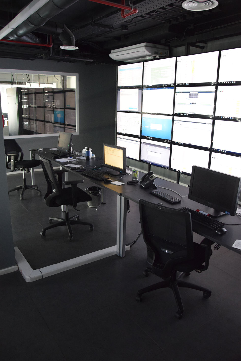 Oficina moderna con computadoras y pantallas grandes. Atelier3ofcial presenta diseño industrial.