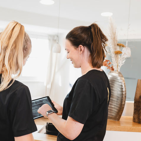 Ärztinnen des Veedelzahnarzt in Köln-Sülz werten ein 3D-Röntgenbild am Tablet aus.